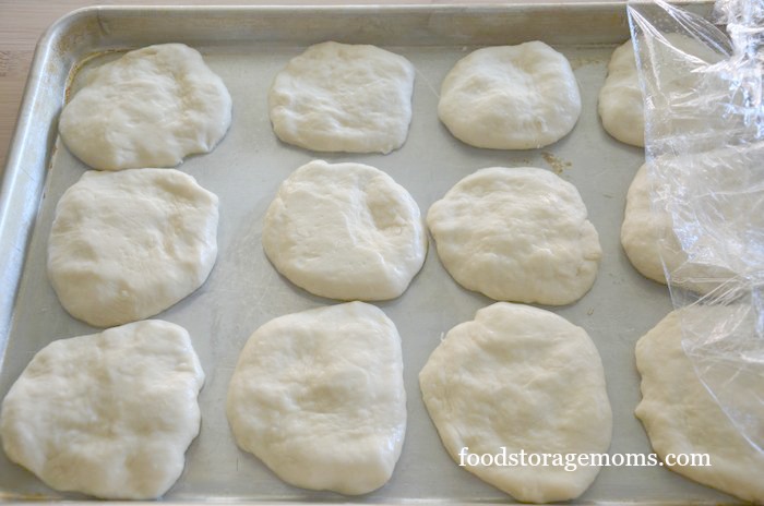Hamburger bread dough on a baking sheet ready to be put in the oven